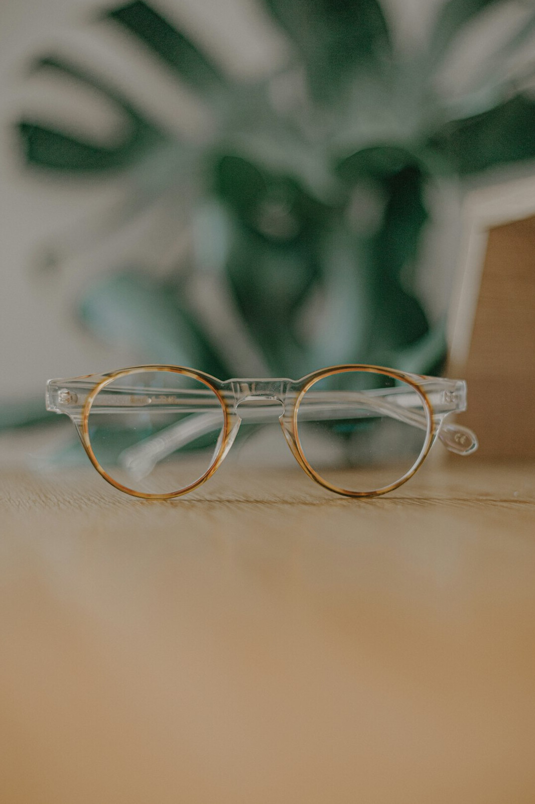 Stacked books and reading glasses on a desk